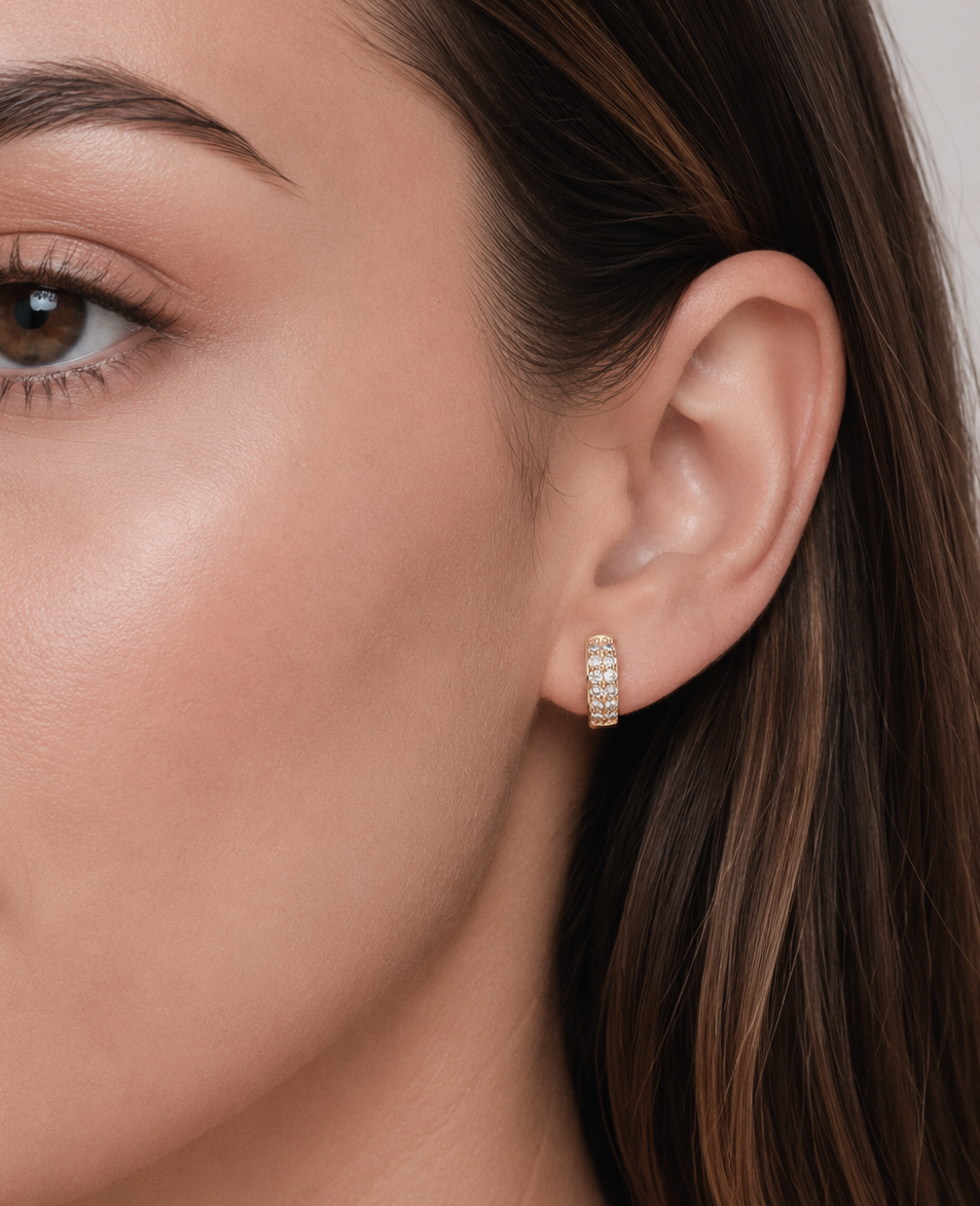 Gold diamond loop earring worn on ear, side profile view