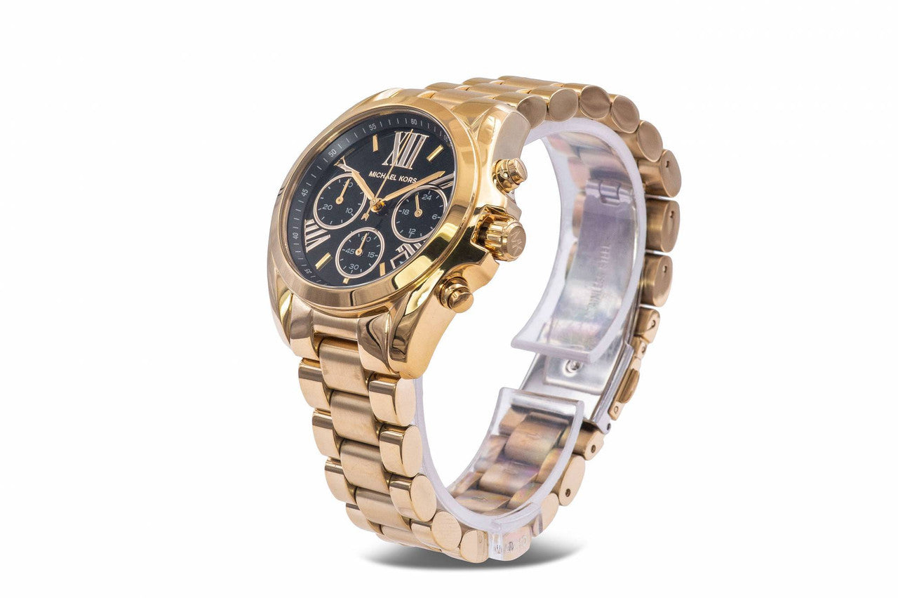 Side angle view of Michael Kors Bradshaw watch showing gold bracelet and black chronograph dial